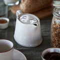 Beja White and Cream Stoneware Teapot — styled with coordinating tableware; individual item sold separately