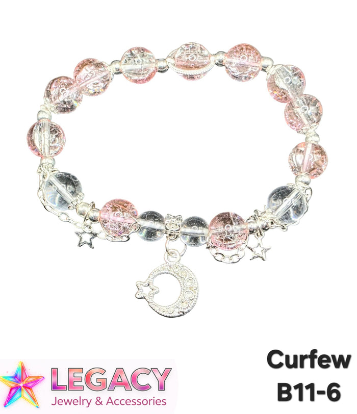 A beaded stretch bracelet with pink and clear faceted beads, silver-toned metal links, small star charms, and a crescent moon charm with a star, shown on a white background with 'LEGACY Jewelry & Accessories' and 'Curfew B11-6' text.