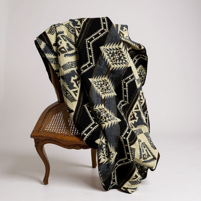 Patterned blanket Cuzco Stone Alpaca Wool Blanket draped over a vintage wooden chair — handcrafted Ecuadorian artisan textile from Enchanted Farms