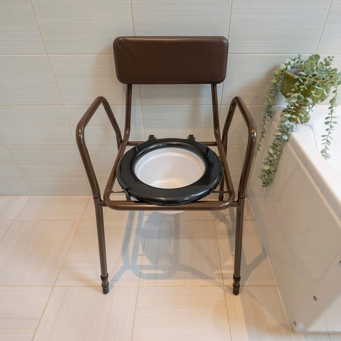 NRS Dovedale Adjustable Commode with Detachable Arms positioned in a home environment such as a bedroom or bathroom, demonstrating its discreet appearance.