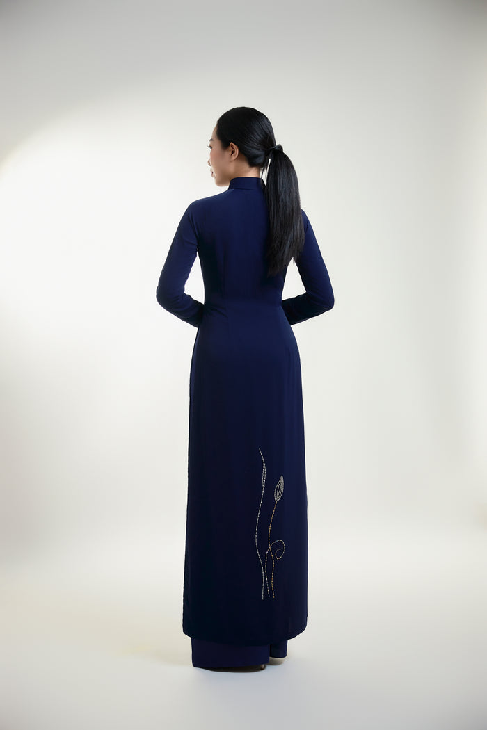 Traditional hand-beaded Ao Dai featuring intricate lotus designs, showcasing elegance and cultural heritage from the back view.